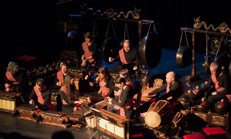 Full Gamelan orchestra on stage with performers.